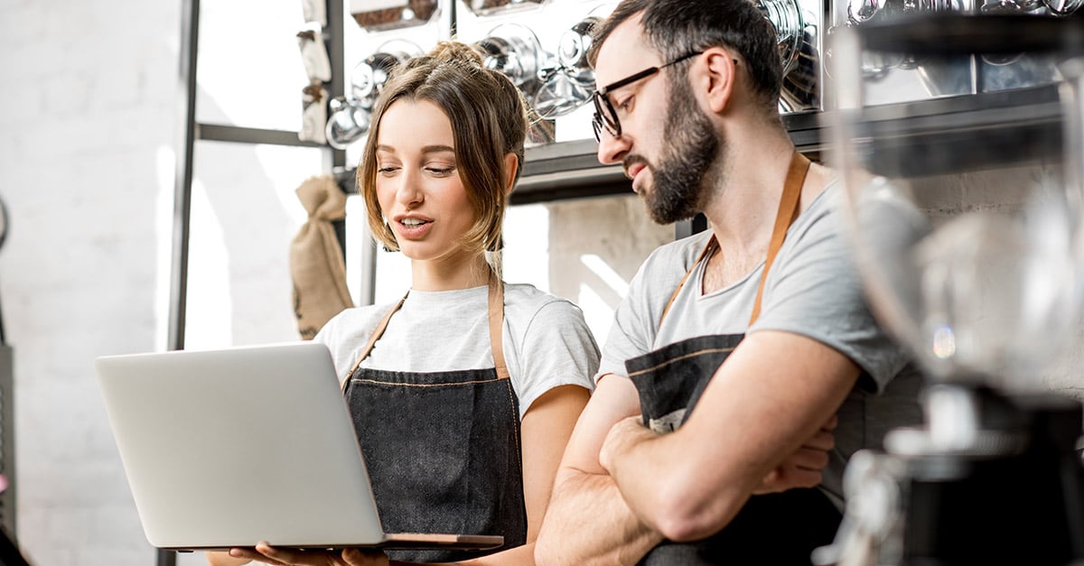 Hospitality staff looking at a screen in a restaurant setting 