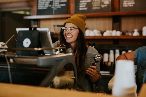 happy waiter using pos system in cafe