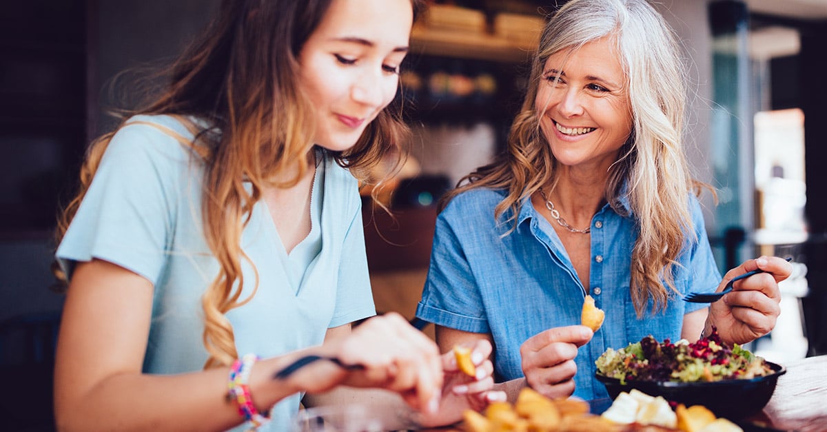 Mother and daughter eating food at a cafe