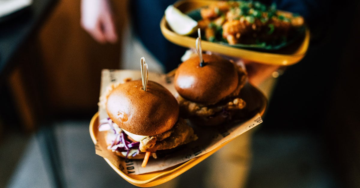 waitress  bring customers burgers to their table