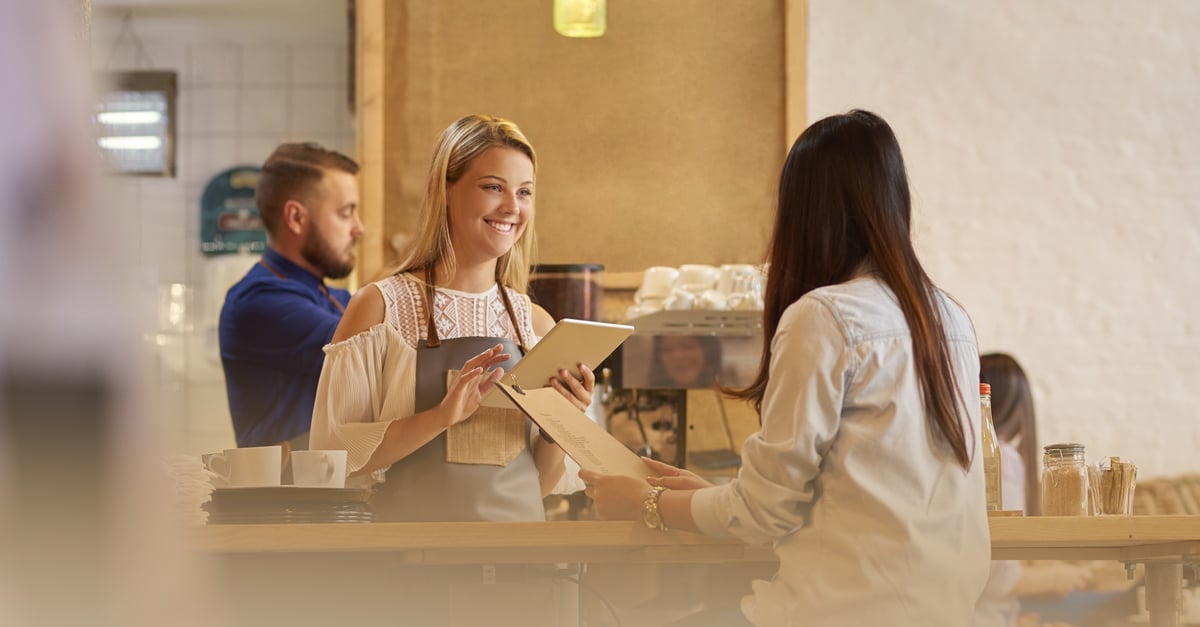 customer giving their food order to a  waitress in a cafe