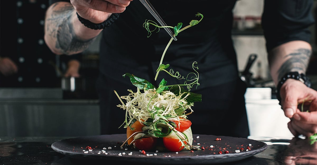 Chef adding the final touches to a dish in a restaurant 