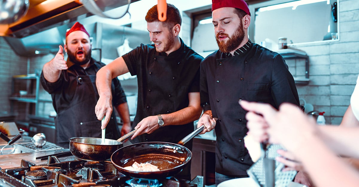 hospitality workers together working in the kitchen cooking