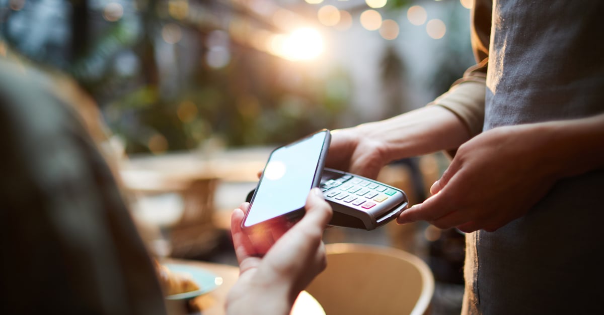 restaurant customer paying at their table for their meal with their phone on a Tyro terminal.