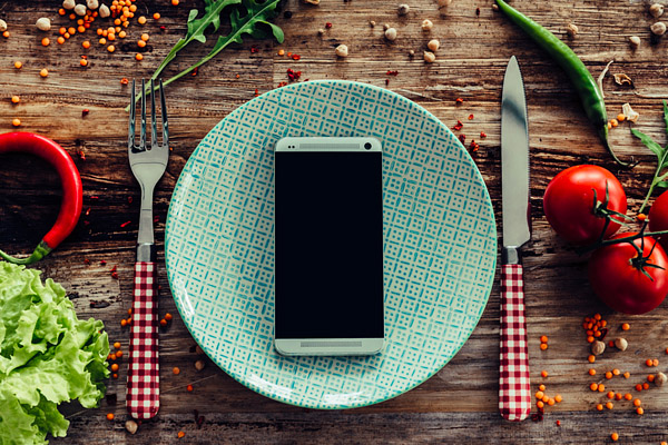 mobile phone on a plate with knife and fork