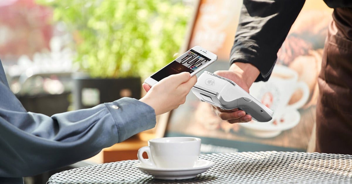 customer at a cafe paying with their phone at their table