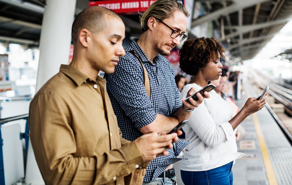 people on phones on train platform