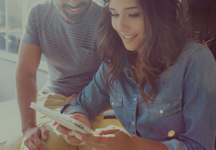 Couple checking out a tablet