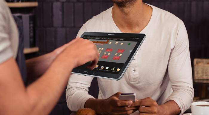 Waiter using an OrderMate tablet using the table mode display putting in an order 