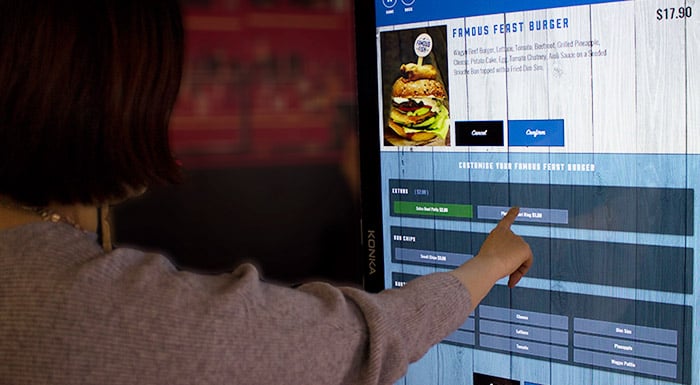 Customer putting through their own order on a self-service kiosk 