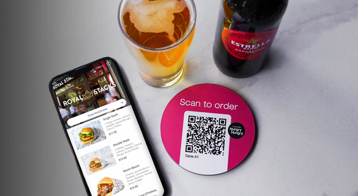 A restaurants digital menu displayed on a phone and the QR code they scanned to bring up the online menu which they ordered their drinks through on table
