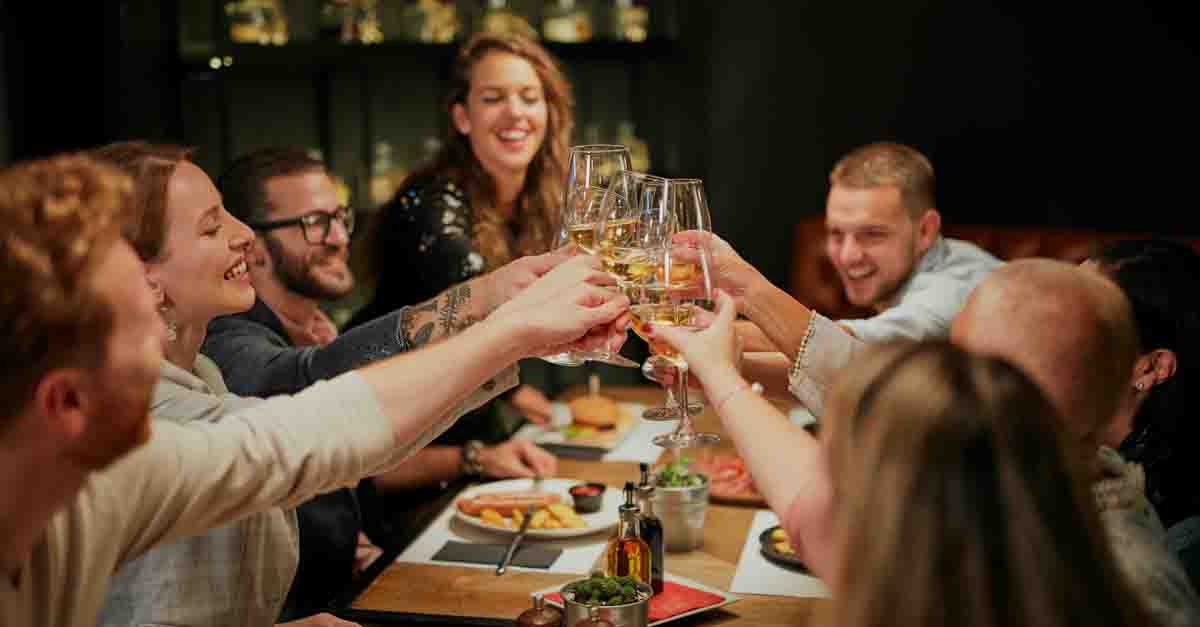 Group of diners clinking their wine glasses over dinner at their favourite restaurant 