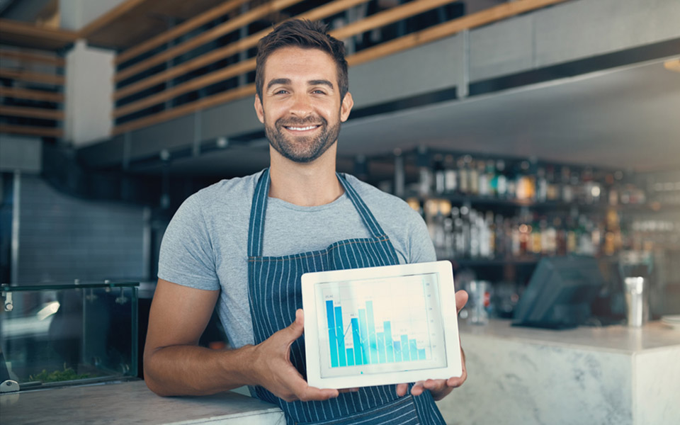 restaurant manager holding tablet with pos system reports