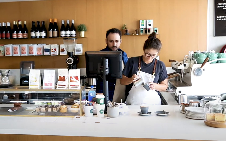 Manager and staff behind the counter at the cafe