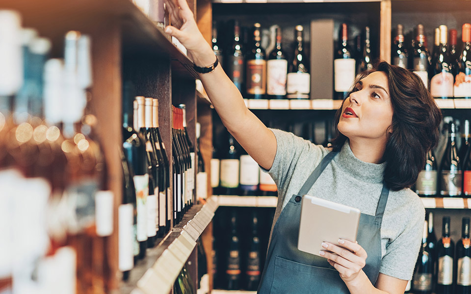 Manager counting wine bottles for stock management