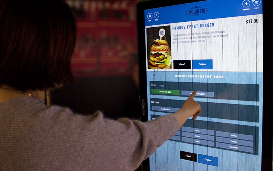 Customer putting in their own order using a self-service kiosk 