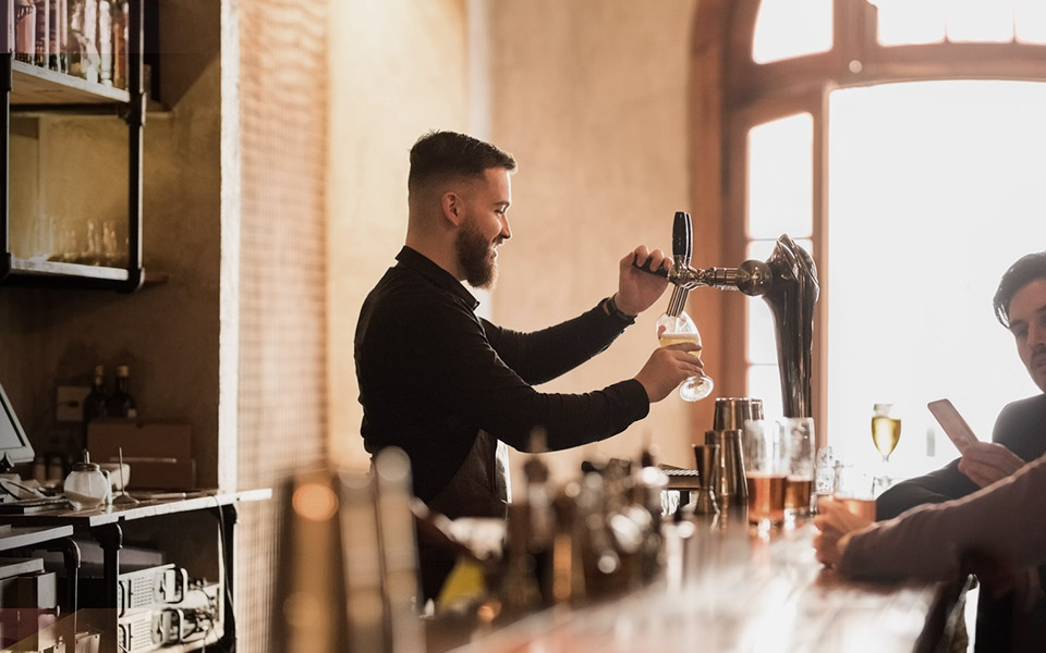 Bar tender pouring a beer in a pub